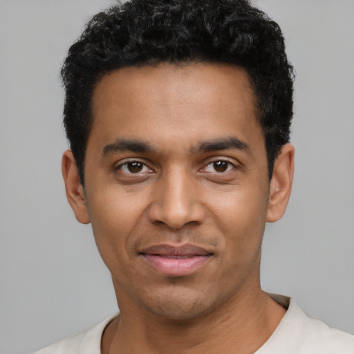 Joyful latino young-adult male with short  black hair and brown eyes