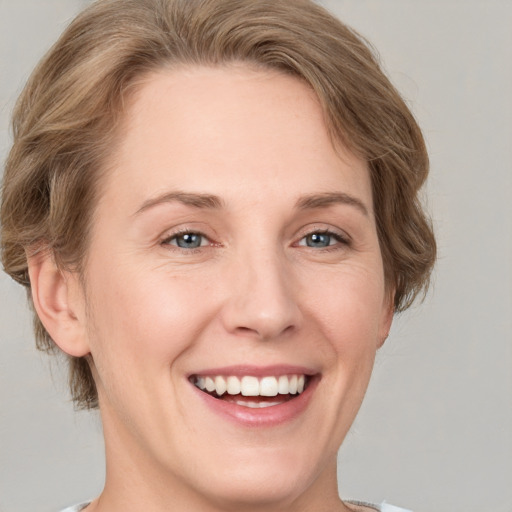 Joyful white young-adult female with short  brown hair and grey eyes