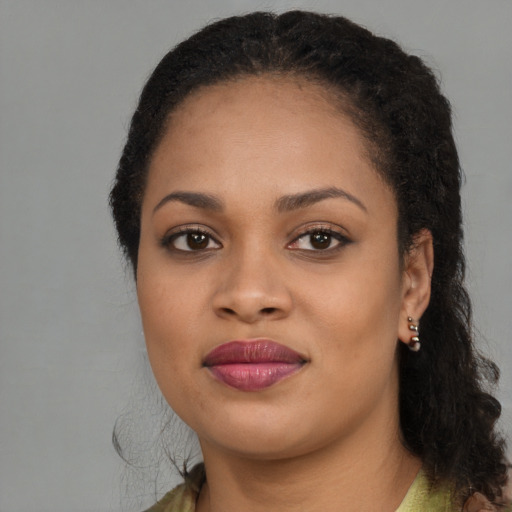 Joyful black young-adult female with long  brown hair and brown eyes