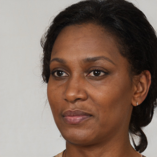 Joyful black adult female with medium  brown hair and brown eyes