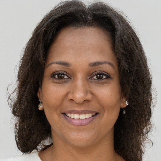 Joyful black young-adult female with long  brown hair and brown eyes