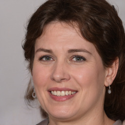 Joyful white adult female with medium  brown hair and grey eyes