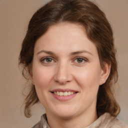 Joyful white young-adult female with medium  brown hair and green eyes