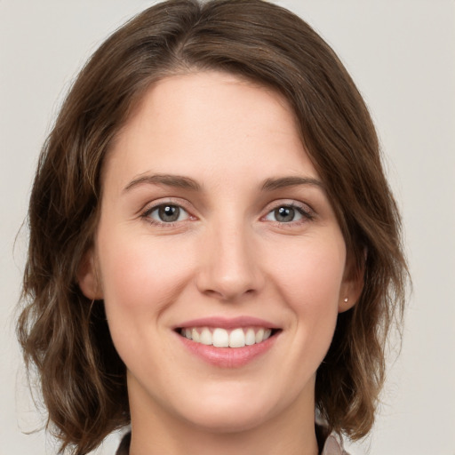 Joyful white young-adult female with medium  brown hair and green eyes