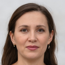 Joyful white adult female with long  brown hair and grey eyes