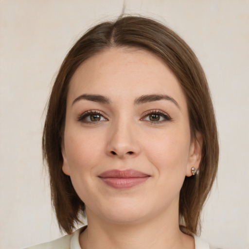 Joyful white young-adult female with medium  brown hair and green eyes