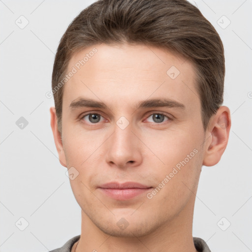 Joyful white young-adult male with short  brown hair and grey eyes