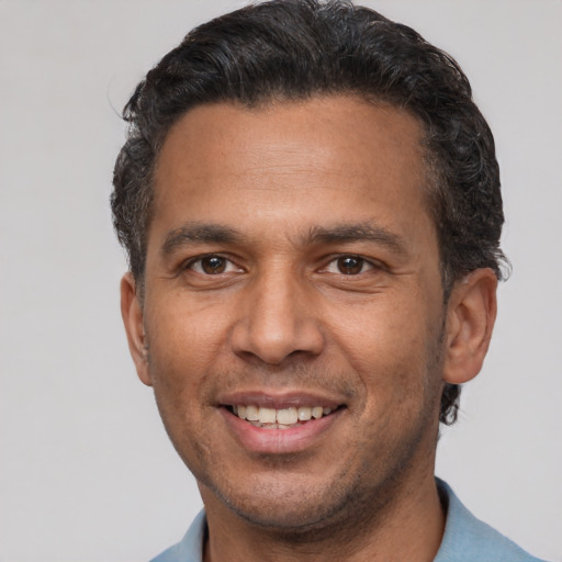 Joyful latino adult male with short  brown hair and brown eyes