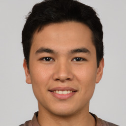 Joyful asian young-adult male with short  brown hair and brown eyes