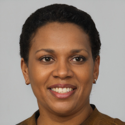 Joyful black adult female with short  black hair and brown eyes