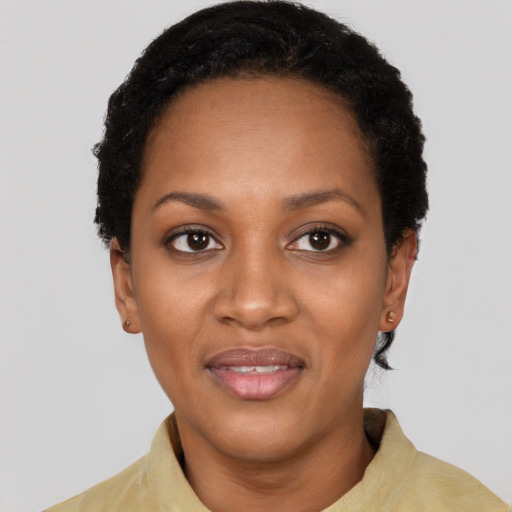 Joyful black young-adult female with short  black hair and brown eyes