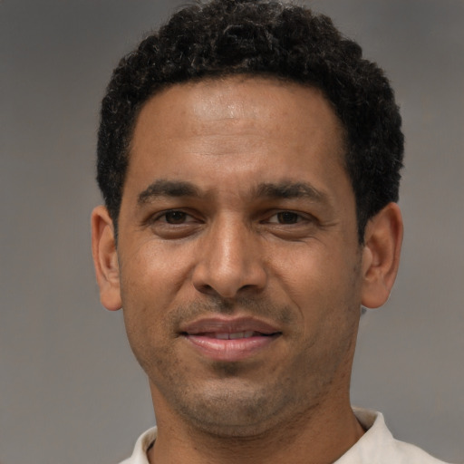 Joyful latino adult male with short  black hair and brown eyes