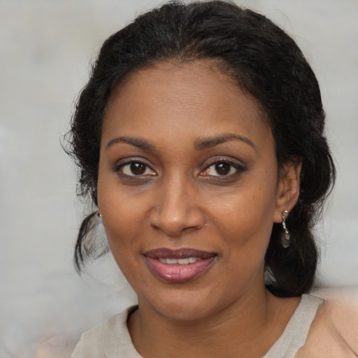 Joyful black adult female with medium  brown hair and brown eyes