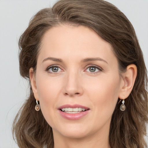 Joyful white young-adult female with long  brown hair and grey eyes