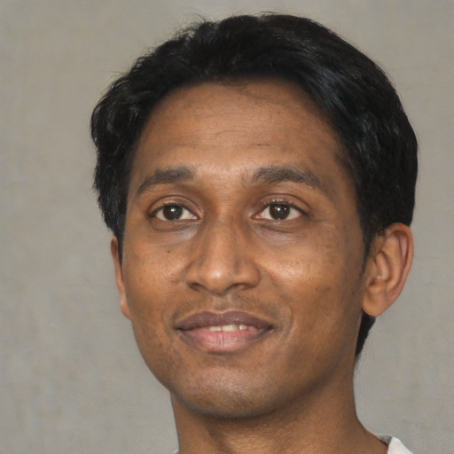 Joyful black adult male with short  black hair and brown eyes