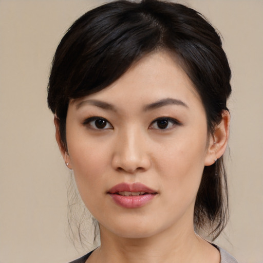 Joyful asian young-adult female with medium  black hair and brown eyes
