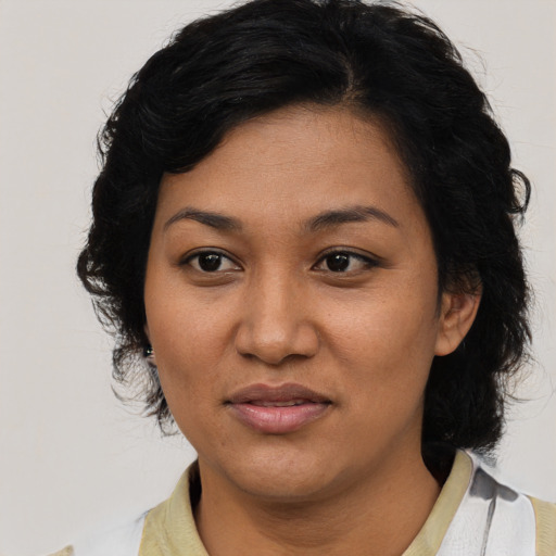 Joyful latino adult female with medium  black hair and brown eyes
