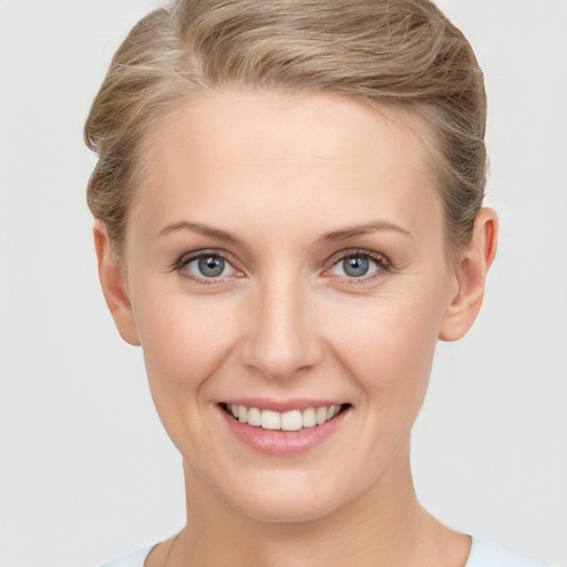 Joyful white young-adult female with short  brown hair and blue eyes