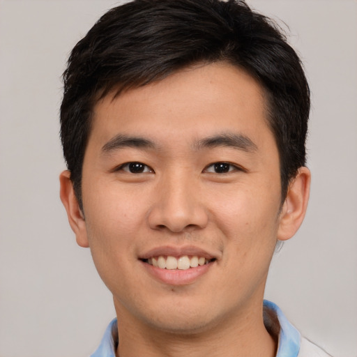 Joyful asian young-adult male with short  brown hair and brown eyes