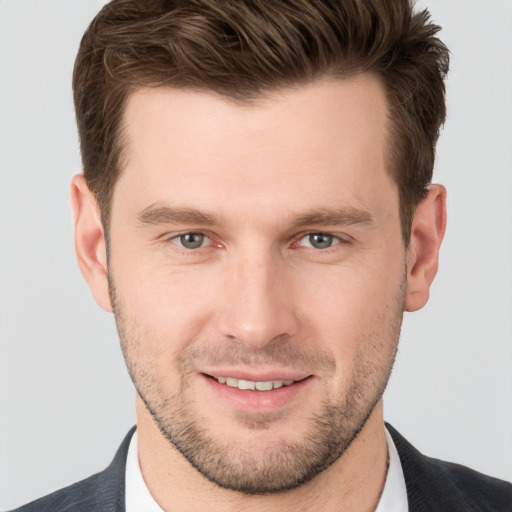 Joyful white young-adult male with short  brown hair and grey eyes