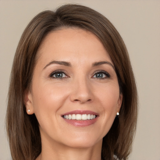 Joyful white young-adult female with medium  brown hair and green eyes