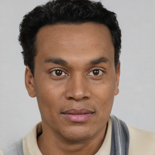 Joyful latino young-adult male with short  black hair and brown eyes