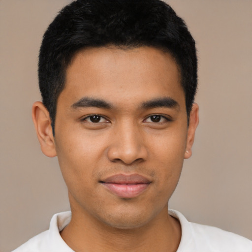 Joyful latino young-adult male with short  black hair and brown eyes