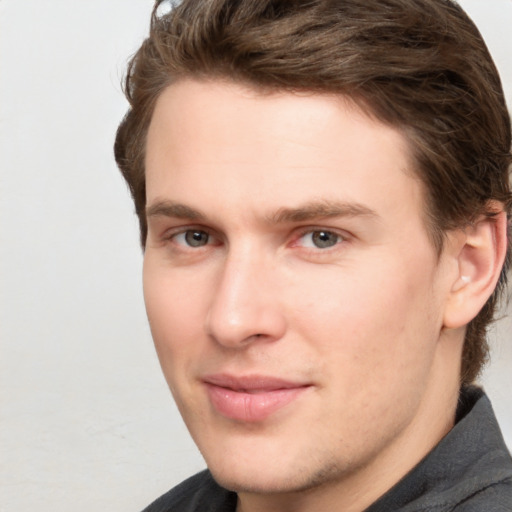 Joyful white young-adult male with medium  brown hair and grey eyes