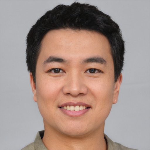 Joyful asian young-adult male with short  black hair and brown eyes