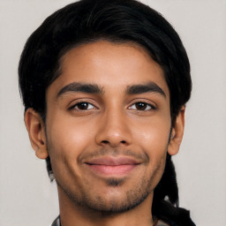 Joyful latino young-adult male with short  black hair and brown eyes