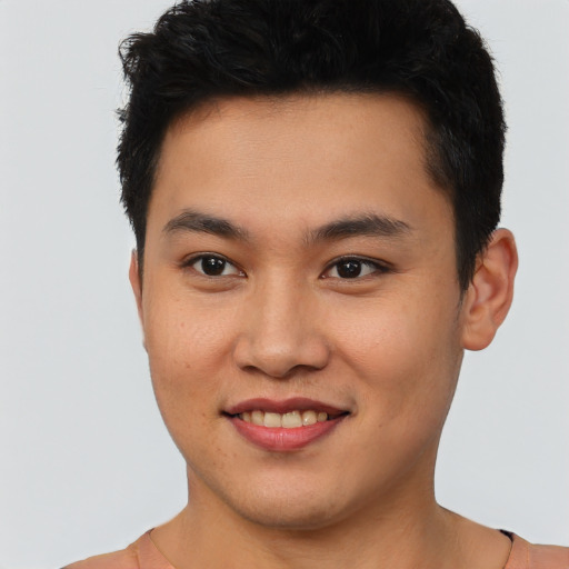 Joyful asian young-adult male with short  brown hair and brown eyes
