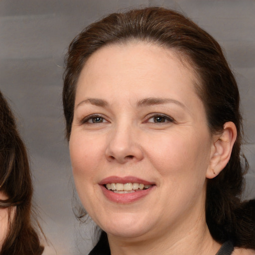 Joyful white adult female with medium  brown hair and brown eyes