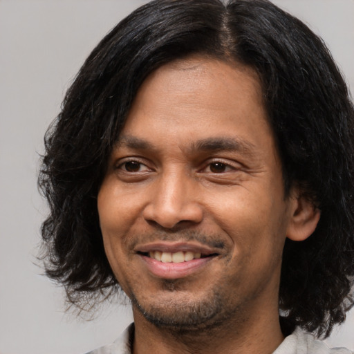 Joyful white young-adult male with medium  black hair and brown eyes