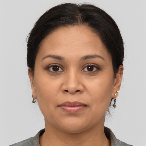 Joyful latino young-adult female with medium  brown hair and brown eyes