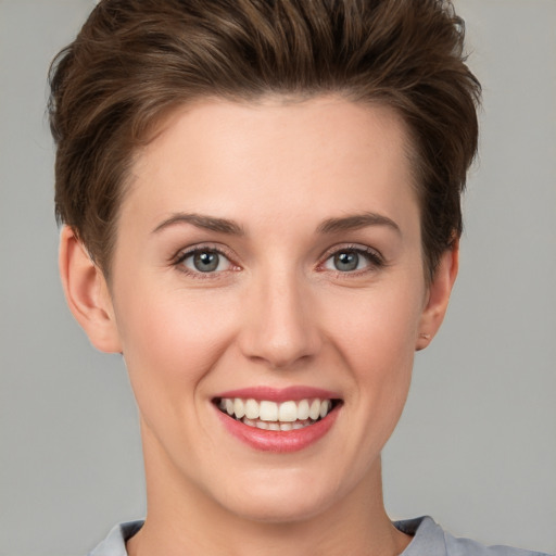 Joyful white young-adult female with short  brown hair and grey eyes