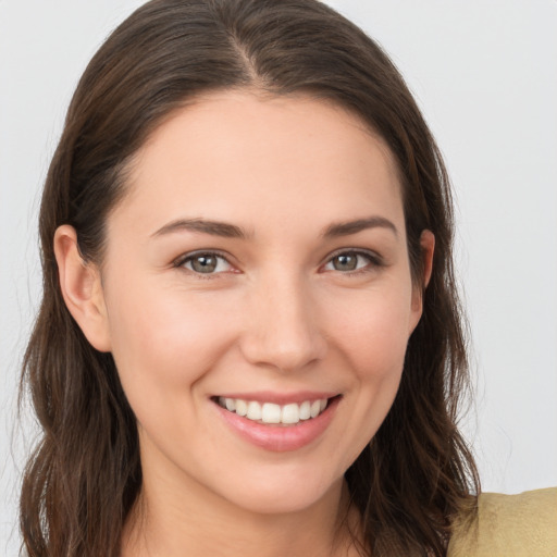 Joyful white young-adult female with long  brown hair and brown eyes