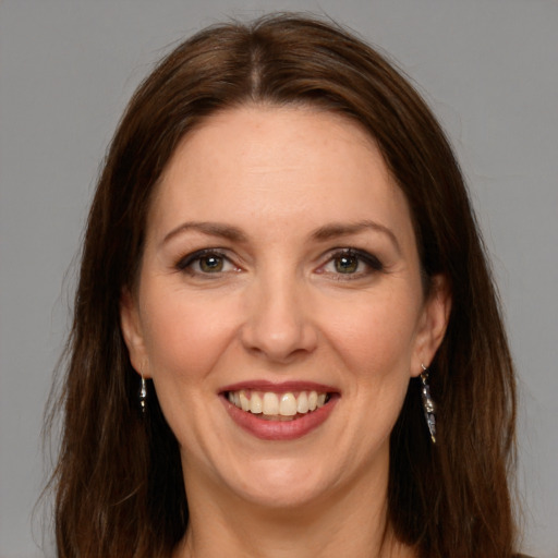 Joyful white adult female with long  brown hair and brown eyes