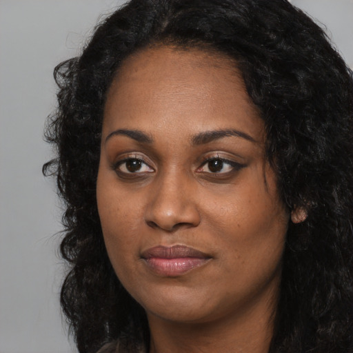Joyful black young-adult female with long  black hair and brown eyes