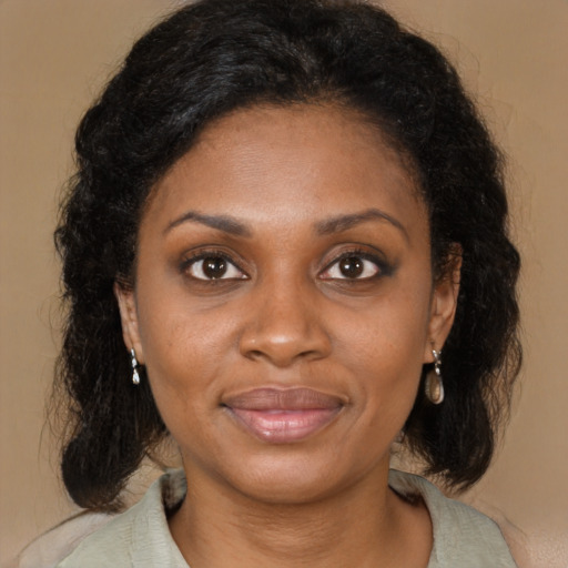 Joyful black adult female with medium  brown hair and brown eyes