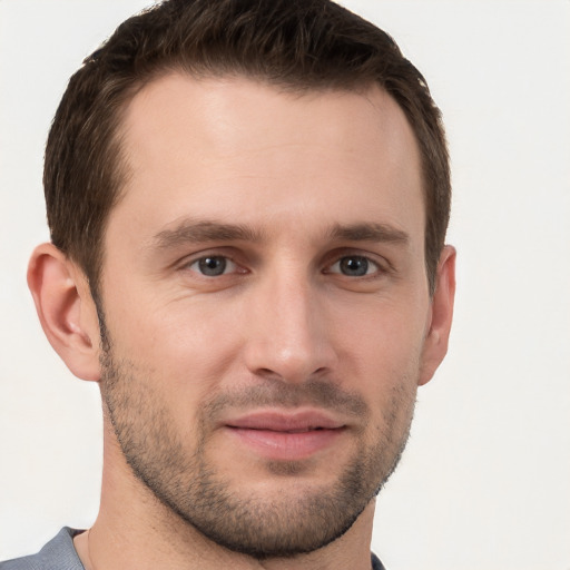 Joyful white young-adult male with short  brown hair and grey eyes