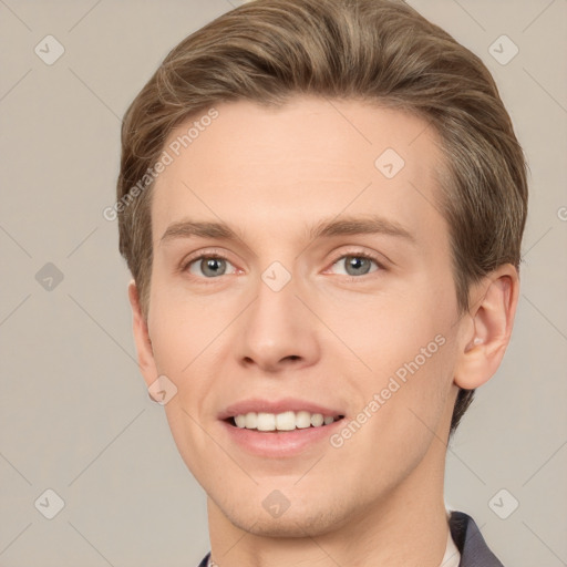 Joyful white young-adult male with short  brown hair and grey eyes