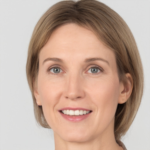 Joyful white adult female with medium  brown hair and grey eyes