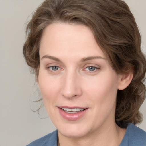 Joyful white young-adult female with medium  brown hair and blue eyes