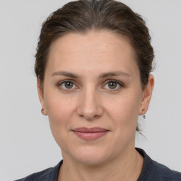 Joyful white adult female with medium  brown hair and grey eyes