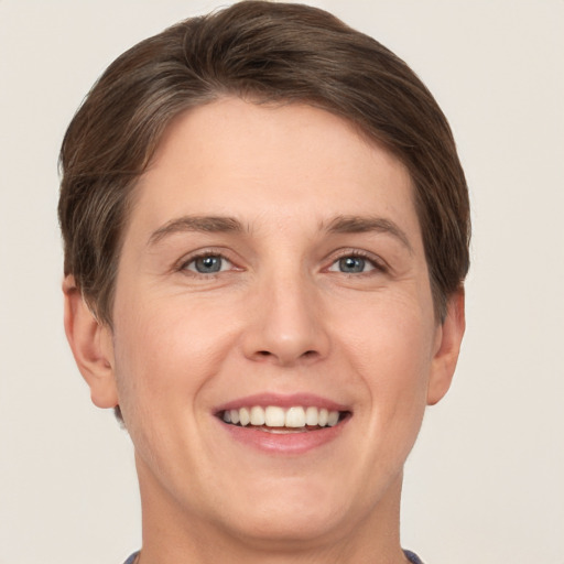 Joyful white young-adult female with short  brown hair and grey eyes