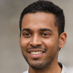 Joyful black young-adult male with short  black hair and brown eyes