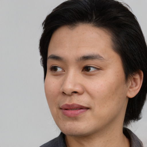 Joyful asian young-adult male with medium  brown hair and brown eyes