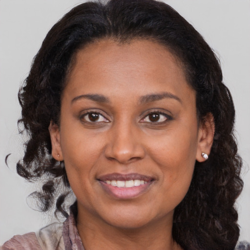 Joyful black adult female with long  brown hair and brown eyes