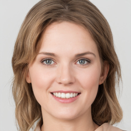 Joyful white young-adult female with medium  brown hair and green eyes