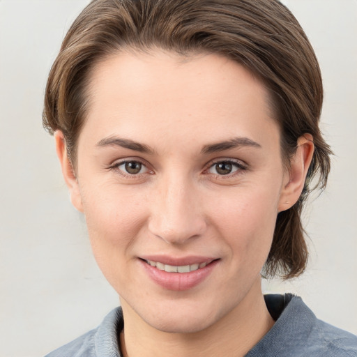 Joyful white young-adult female with medium  brown hair and grey eyes